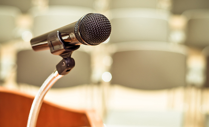 Microphone on a podium in an empty auditorium ready for public speaking.